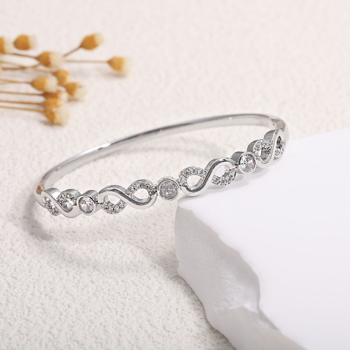 Women's bangle with elegant infinity pattern and sparkling zirconia Style and Serve